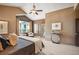 Spacious main bedroom featuring neutral decor, sitting area, ceiling fan, and doorway to outside patio area at 13087 W 27Th Ln, Golden, CO 80401