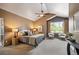 Well-lit main bedroom featuring vaulted ceiling, ceiling fan, bedside lamps, and sitting area with lush outdoor views at 13087 W 27Th Ln, Golden, CO 80401