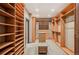 Spacious walk-in closet featuring custom wood shelving, carpeted floor, and center island with granite countertop at 13087 W 27Th Ln, Golden, CO 80401
