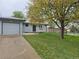 Inviting home with a well-maintained front lawn, mature tree, long driveway, and freshly painted gray exterior at 795 Vivian Ct, Lakewood, CO 80401