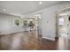 Open-concept living room showcasing hardwood floors, and seamless flow to the kitchen and bathroom at 765 Iola St, Aurora, CO 80010