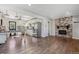 Open-concept living room showcasing hardwood floors, a brick fireplace, and seamless flow to the kitchen at 765 Iola St, Aurora, CO 80010