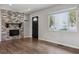 Stylish living room boasting a brick fireplace, hardwood floors, and a large window for ample natural light at 765 Iola St, Aurora, CO 80010