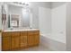 Bathroom featuring a double sink vanity with wood cabinets and a full tub at 8358 S Independence # 107, Littleton, CO 80128