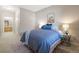 Comfortable bedroom with a plush blue comforter, neutral walls, and a glimpse into the en-suite bathroom at 8358 S Independence # 107, Littleton, CO 80128