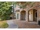 Attractive condo exterior showcasing stone pillars, covered entryway, and mature trees at 8358 S Independence # 107, Littleton, CO 80128