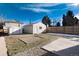 Spacious backyard featuring a well-maintained lawn, storage shed, and defined gravel areas at 2301 E Yale Ave, Denver, CO 80210