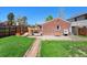 Backyard with a patio, wooden deck with dining set, brick exterior, and a well-maintained lawn at 2301 E Yale Ave, Denver, CO 80210