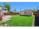 Expansive backyard featuring lush green grass, a storage shed, a detached garage, and mature trees at 2301 E Yale Ave, Denver, CO 80210