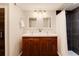 Modern bathroom featuring double sinks, a wooden vanity, and a tiled shower at 2301 E Yale Ave, Denver, CO 80210