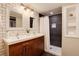 Bright bathroom features double sinks, modern fixtures, stylish tile shower, and built-in shelving at 2301 E Yale Ave, Denver, CO 80210