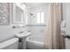 Classic bathroom featuring a shower-tub combo, pedestal sink, classic tile, and window for natural light at 2301 E Yale Ave, Denver, CO 80210