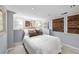 Basement bedroom featuring neutral colored carpet, a large bed, and two windows covered by wooden blinds at 2301 E Yale Ave, Denver, CO 80210