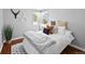 Cozy bedroom features a plush bed, decorative pillows, hardwood floors, natural light, and stylish decor at 2301 E Yale Ave, Denver, CO 80210