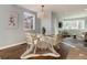 Bright dining room with hardwood floors, modern lighting, and a chic round glass table for stylish dining at 2301 E Yale Ave, Denver, CO 80210