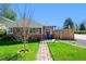 Charming brick home with a blue door and a pergola leading to the entrance at 2301 E Yale Ave, Denver, CO 80210