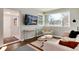 Cozy living room featuring large windows, stylish furniture, and a mounted TV, perfect for relaxing at 2301 E Yale Ave, Denver, CO 80210