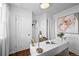 Bright home office boasts hardwood floors, white walls, white desk, decorative art, and ample natural light at 2301 E Yale Ave, Denver, CO 80210