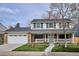 Inviting two-story home with brick facade, white trim, a covered porch, and green lawn at 7343 S Ivy Way, Centennial, CO 80112