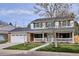 Charming two-story home with brick accents, a covered porch, and a well-manicured lawn at 7343 S Ivy Way, Centennial, CO 80112
