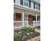 Well-maintained home with a brick facade, white porch railing, and beautiful landscaping detail at 7343 S Ivy Way, Centennial, CO 80112