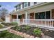 Charming home with brick accents, white porch railing, and beautiful landscaping and flowers at 7343 S Ivy Way, Centennial, CO 80112