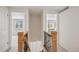 Hallway with natural light, white walls, and wooden banisters leading to carpeted bedrooms and living areas at 7343 S Ivy Way, Centennial, CO 80112