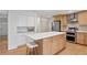Modern kitchen island with stainless steel appliances and light wood cabinetry at 7343 S Ivy Way, Centennial, CO 80112