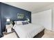 View of bedroom with closet, a decorative blue wall and a king sized bed at 1201 Galapago St # 109, Denver, CO 80204