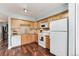 Bright kitchen featuring wood cabinets, granite countertops, and white appliances at 1201 Galapago St # 109, Denver, CO 80204