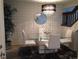 Elegant dining area with modern chandelier, glass table, white chairs, and stylish wallpaper at 4663 S Fraser Ct # C, Aurora, CO 80015