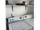 The laundry room features modern washer and dryer under an open shelf with decorative items at 4663 S Fraser Ct # C, Aurora, CO 80015