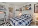Inviting bedroom with playful decor, laundry in hall, and comfortable queen-sized bed with blue plaid cover at 11440 E Martin Luther King Jr Blvd, Denver, CO 80238