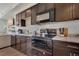 Modern kitchen with sleek countertops, dark wood cabinetry, and stainless steel appliances at 11440 E Martin Luther King Jr Blvd, Denver, CO 80238