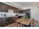 Well-lit kitchen with dark wood cabinets, modern appliances, and a cozy dining area at 11440 E Martin Luther King Jr Blvd, Denver, CO 80238