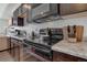 Close-up view of the kitchen featuring sleek countertops, dark wood cabinets, and a modern range at 11440 E Martin Luther King Jr Blvd, Denver, CO 80238