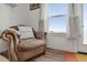 Cozy chair in the living room next to the window with natural lighting and white walls at 11440 E Martin Luther King Jr Blvd, Denver, CO 80238