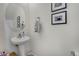 Charming powder room with a pedestal sink, decorative mirror, and tasteful wall decor at 11440 E Martin Luther King Jr Blvd, Denver, CO 80238