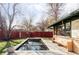 Backyard featuring a rectangular pool and lush landscaping including mature trees and a brick fence at 3050 S Marion St, Englewood, CO 80113