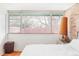 Comfortable bedroom featuring hardwood floors, large windows, and a white brick accent wall at 3050 S Marion St, Englewood, CO 80113