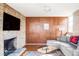 Cozy living room with a brick fireplace, wood paneled accent wall and comfortable seating at 3050 S Marion St, Englewood, CO 80113