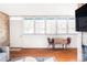 Living room and dining area boasts large windows, hardwood floors, and brick fireplace at 3050 S Marion St, Englewood, CO 80113