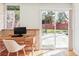 Bright office space featuring a wooden desk, large windows, and access to the outdoor patio through sliding glass doors at 3050 S Marion St, Englewood, CO 80113