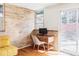 Bright office area with brick accent wall, desk, and sliding door with backyard view at 3050 S Marion St, Englewood, CO 80113