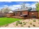 Backyard featuring wood deck, seating, and lush landscaping at 2120 N Poplar St, Denver, CO 80207