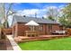 Brick home featuring a wood deck perfect for entertaining in the backyard at 2120 N Poplar St, Denver, CO 80207