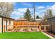 Backyard featuring raised garden beds, wooden fence, and charming garden shed at 2120 N Poplar St, Denver, CO 80207