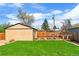Backyard featuring lush green lawn, a storage shed, and a fenced garden area at 2120 N Poplar St, Denver, CO 80207