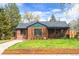 Beautiful brick home featuring a well-kept lawn, complemented by mature trees at 2120 N Poplar St, Denver, CO 80207