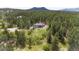 Expansive property featuring a house nestled among dense trees with mountain views at 1988 Lake Dr, Larkspur, CO 80118